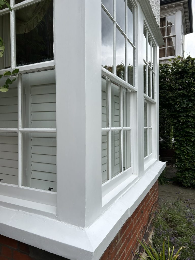 Finished Victorian sash window restoration in white high-gloss heritage coating by Loveday Decorators.