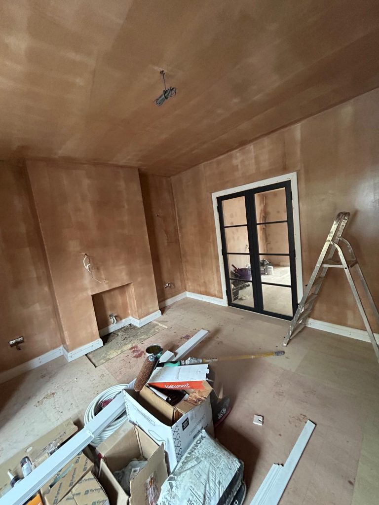 Bare plaster wall sealed with Gardz prior to matte black feature wall finish in London home