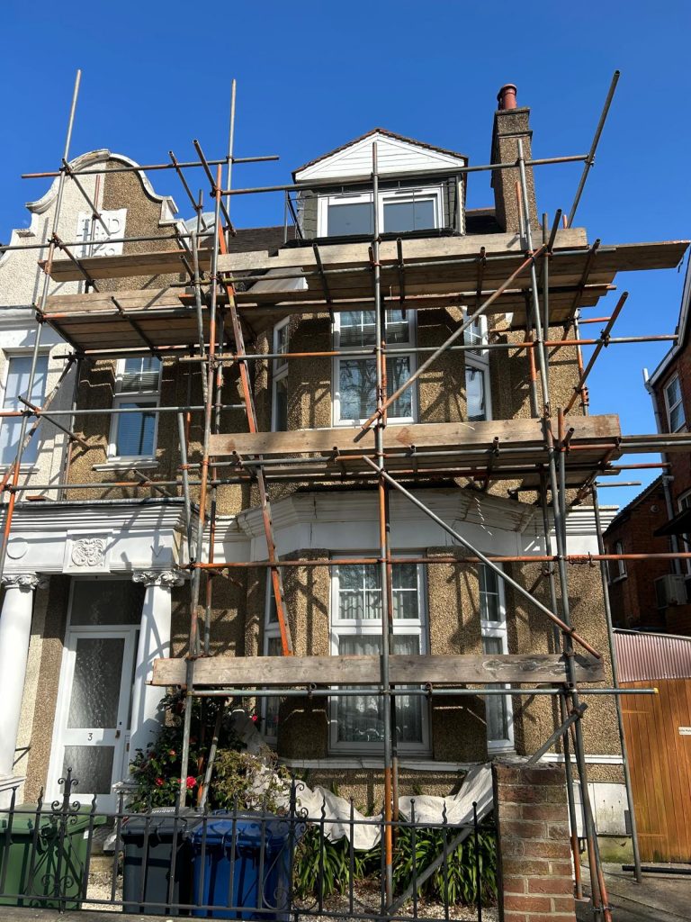 Exterior property restoration in progress with scaffolding by Loveday Decorators, London.